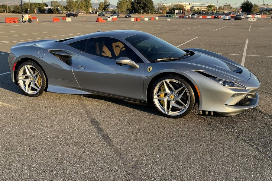 Silver Ferrari F8 Tributo at golden hour with palm trees and mountains behind